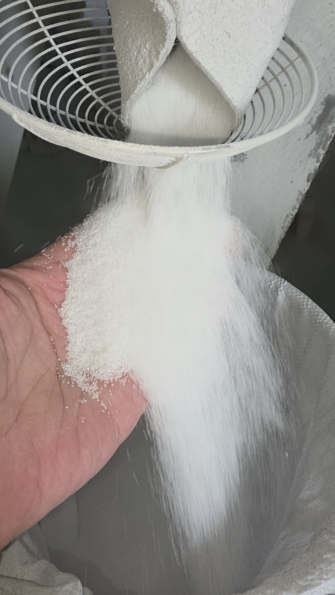 White fused alumina P grit streaming from a grading sieve